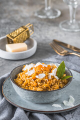 Homemade pumpkin risotto with parmesan cheese on a gray concrete background
