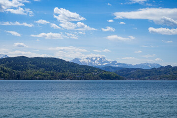 Beautiful and idyllic lake woerthersee in austria. Steep snowy mountains in the background. Klagenfurt, Carinthia, Austria.