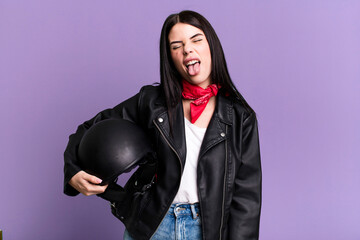with cheerful and rebellious attitude, joking and sticking tongue out. motorbike rider concept