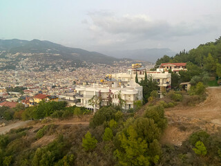 A beautiful tourist city with modern buildings on a mountain with trees, a view from the top of the rooftops on vacation in a warm tropical eastern paradise country southern resort