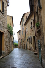 Fototapeta na wymiar Old narrow alley in Volterra at Regen, Tuscany Italy