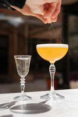 Cocktail making process. Bartender squeezes lemon zest.