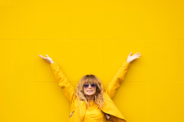 woman excited from happiness on yellow wall outdoors