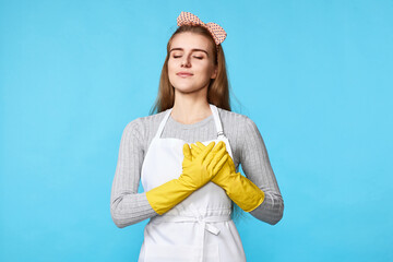 woman in rubber gloves with hands on chest with closed eyes