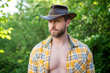 caucasian man in cowboy hat. sexy man in checkered shirt. western man wearing hat
