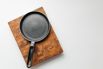Empty pan on wood board. Empty marble coated iron pot