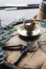 toddy, christmas, holiday, tea, herbal, wood, cup, coffee, drink, cafe, beverage, hot, brown, table, food, black, mug, caffeine, aroma, white, saucer, closeup, spoon, wreath, boughs, pine, vintage, or