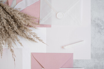 Top view of composition of colorful paper sheets, ribbons, white and pink envelopes, bouquet of...