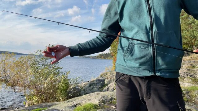 Fishing rod held by a man. Fly fishing. No face. Autumn weather by a Swedish lake. Mälaren, Stockholm, Sweden, Europe