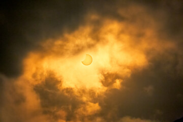 Partial Solar Eclipse through yellow layers of clouds October 2022