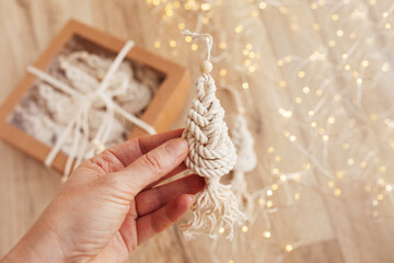 Christmas tree macrame toys on wooden boad.  Natural materials - cotton thread, wood beads and stick. Eco decorations, ornaments, hand made decor. Winter and New Year holidays.