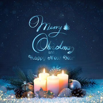 Four burning Advent candles on snow . Christmas background.