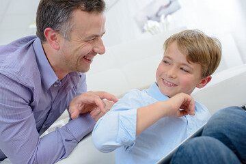 Man walking his fingers up child's back