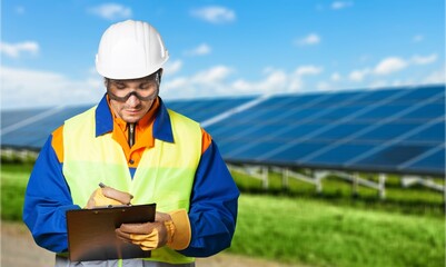 Fototapeta premium Young engineer worker inspecting a solar panel