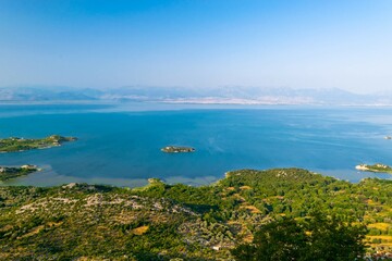 Fototapeta premium Shtegvashe Viewpoint. Beautiful summer landscape of small green islands and blue waters of Lake Skadar near the border with Albania. Montenegro.