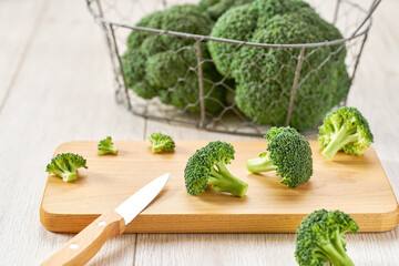 cutting broccoli for baking on a white table, selective focus.
