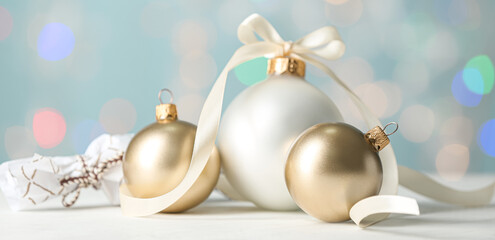 Beautiful Christmas balls on table against blurred lights