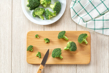cutting broccoli for baking on a white table, top view.