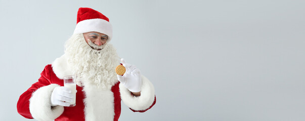 Portrait of Santa Claus with milk and cookie on light background with space for text