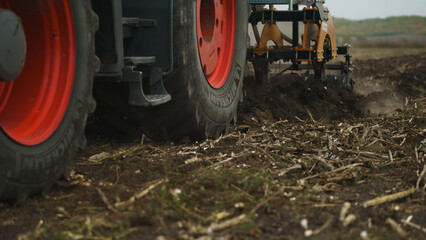 Fototapeta na wymiar Tractor working in the field. Autumn tillage. Deep ripping with powerful tractor