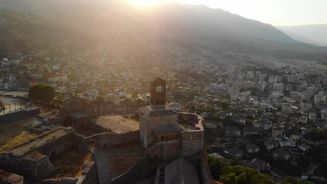 Castle of Gjirokastra and old city center. Aerial view of ancient fortress, houses and mountains in Gjirokaster, Albania