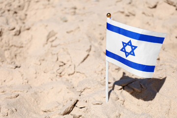 Naklejka premium Flag of Israel on sand, closeup