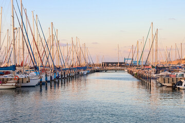 Obraz premium View of beautiful pier with yachts at sunset