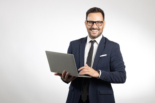 Studio portrait of young business man holding laptop. Picture taken in studio, white background