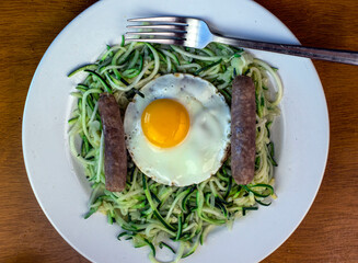 zucchini noodles with fried eggs and sausage