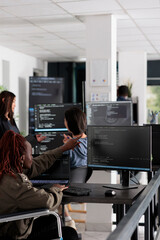 Software programmer with physical disability working on server coding, analyzing programming...