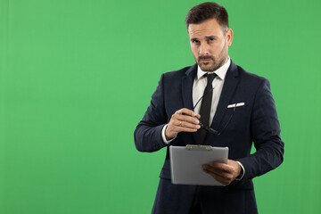 Picutre of a young business man, formal dressed in suit, taking notes and showing emotions while doing it. Studio portrait od green background, suitable for editing
Green screen photo background