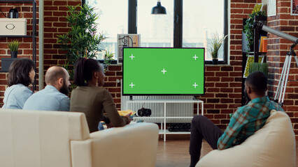 Multiethnic group of people enjoying tv show on greenscreen, watching movie with isolated mockup...