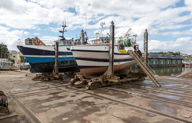 Fishing boats out on dry in dock for maintenance.