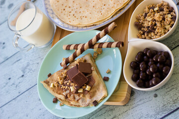 Crepes with chocolate on cutting board with ingredients