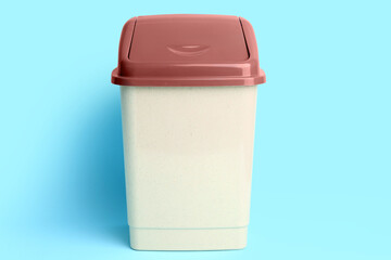 Trash bin on color background