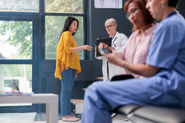 Fototapeta premium Health specialist measuring sugar level with blood sample to do insulin test with glucometer for senior patient with diabetes. Nurse checking glucose at medical checkup examination at clinic.