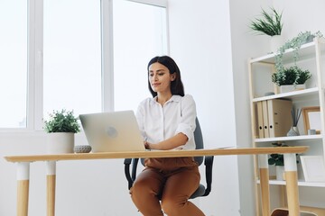 Woman business working at her laptop at home in her office, freelance employee in business,...