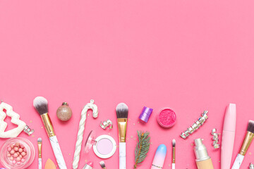 Makeup products with Christmas decor on pink background