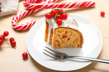 Plate with piece of tasty Christmas cake on wooden table