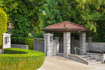 Iron front gate of a beautiful luxury home with landscaping. Gateway of a Country Mansion. Manor...