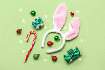 Bunny ears with Christmas decor and gifts on green background