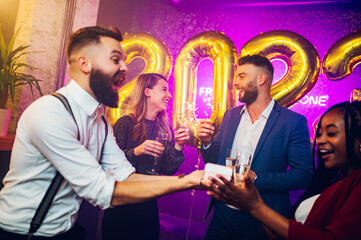 Multiracial friends celebrating new years eve with champagne and sparklers