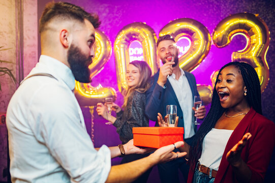 Multiracial couple exchanging gifts for birthday party or new years eve