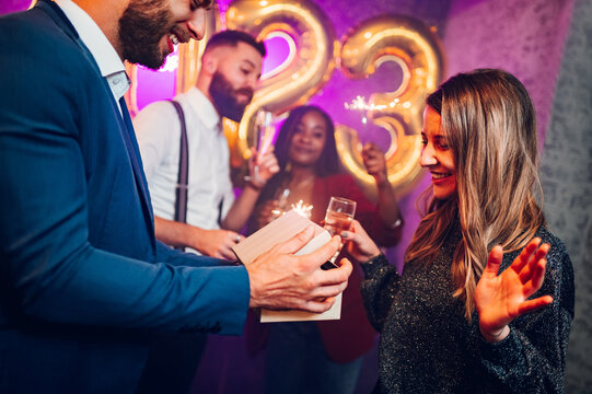 Couple exchanging gifts for birthday party or new years eve in the club