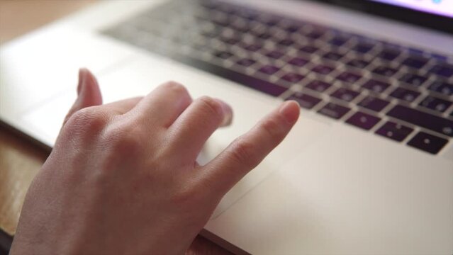 Woman uses modern laptop touchpad or trackpad with her hand. 