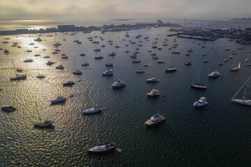Aerial shot of the Newport Harbor in Rhode Island with boats on the water surface and a cloudscape