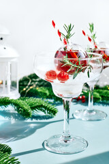 Christmas refreshment drink mimosa, punch or cranberry margarita cocktail serving in christmas ornaments and martini drinking glasses. Delicious icy drink idea for christmas and winter holiday party.