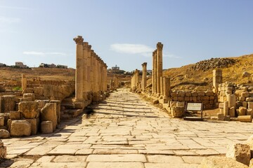 Colonnaded Street with ancient pillars and stones of the Jerash ruins on a sunny day in Jordan