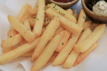 Tasty french fries potato with ketchup on white paper. Hot fast food. Fry delicious snack.