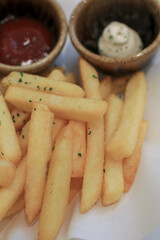 Tasty french fries potato with ketchup on white paper. Hot fast food. Fry delicious snack.
